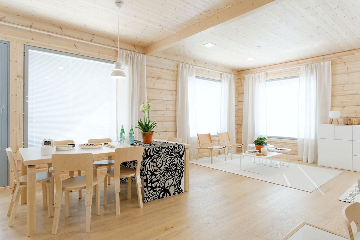 Näkymä Haruniren alakerran eteisestä oleskelutiloihin on väljä ja avara, yhteisiin oleskelutiloihin on varattu runsaasti neliöitä. Ruokailutila sijaitsee avokeittiön vieressä, siitä myös käynti takapihan lasitetulle terassille. Artekin ruokapöytä, 66-tuolit ja Utzon-valaisin sekä Lapuan Kankurin Palttina-pellavaverhot muodostavat rauhallisen kokonaisuuden.